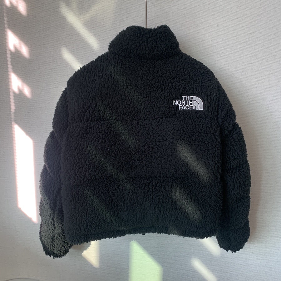 Back side of The North Face Sherpa Nuptse Jacket in black showing embroidered logo on upper back.