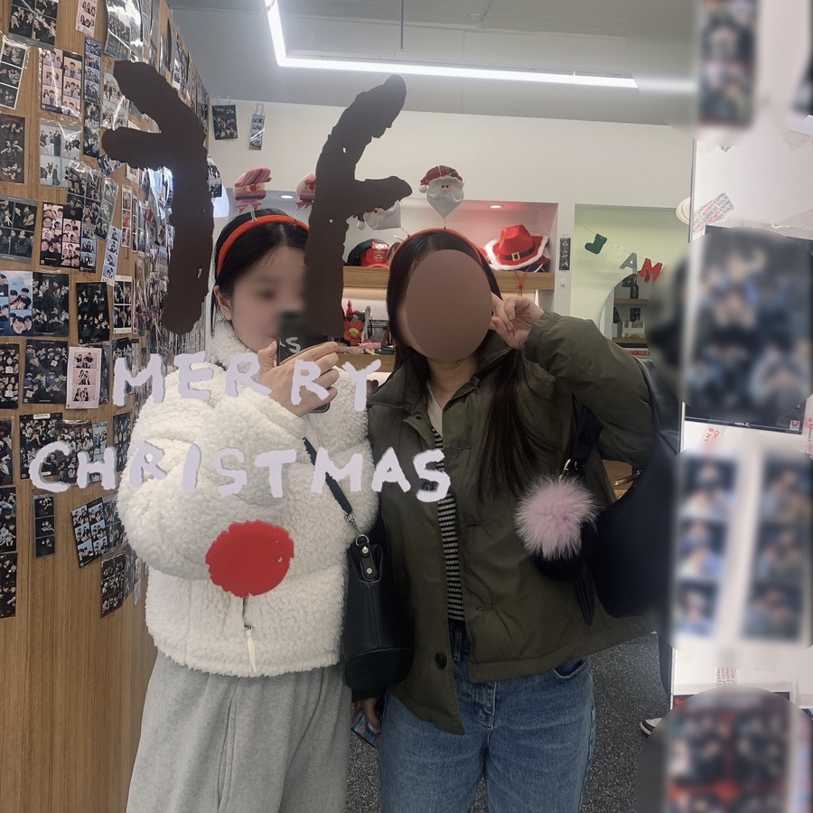 Wearing The North Face Sherpa Nuptse Jacket White while taking Photo Signature pictures at a Christmas-themed photo booth with a friend