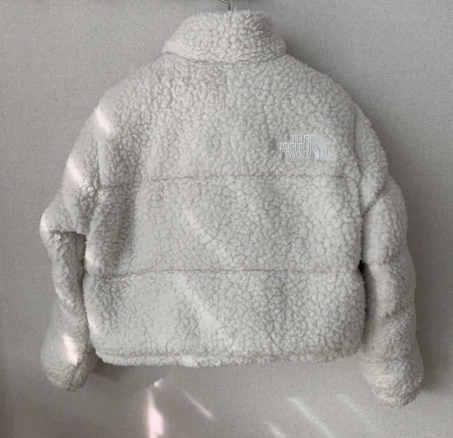 The North Face Sherpa Nuptse Jacket White under natural sunlight showing soft fluffy sherpa texture and cozy fleece fabric
