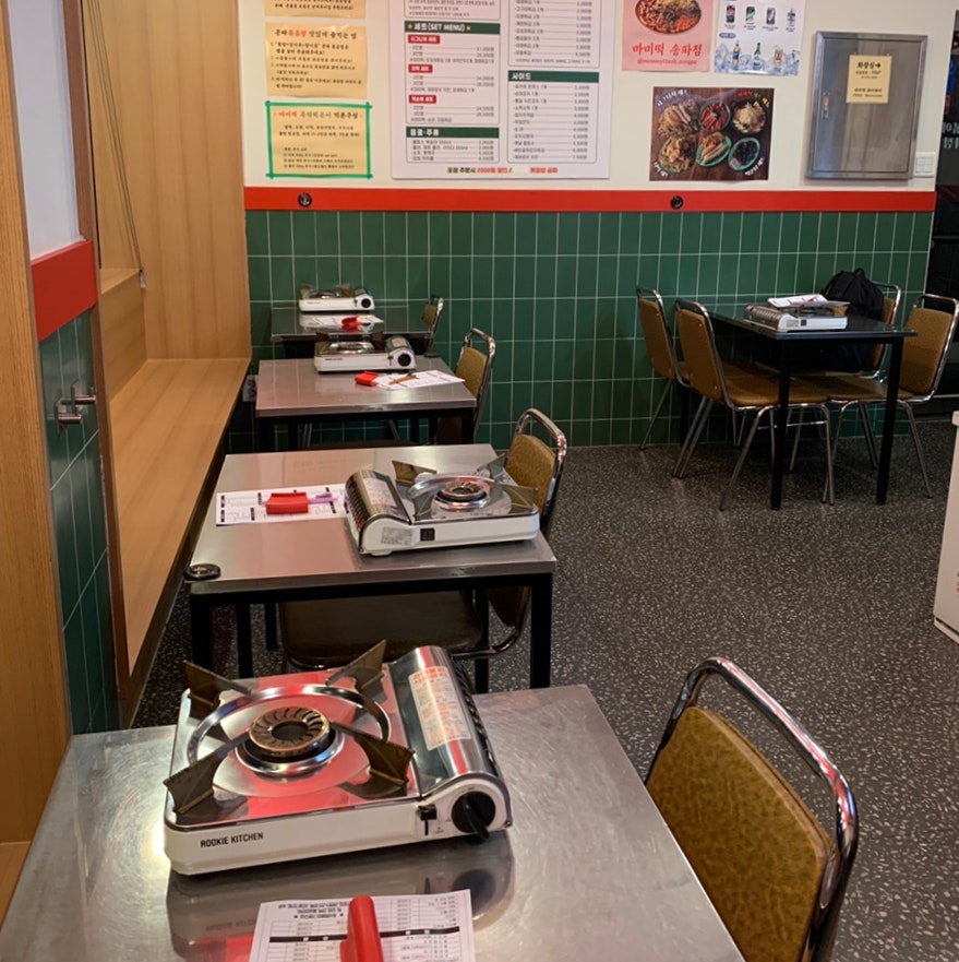 retro-style Korean snack bar interior with green tiles and metal tables at Mommytteok Songpa in Songridangil Jamsil