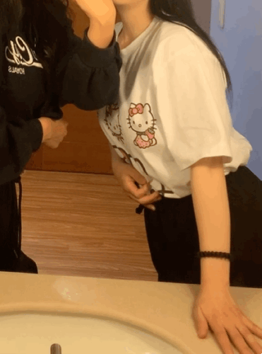 gif wearing Uniqlo Hello Kitty T-shirt in mirror with coworker (workshop photo).