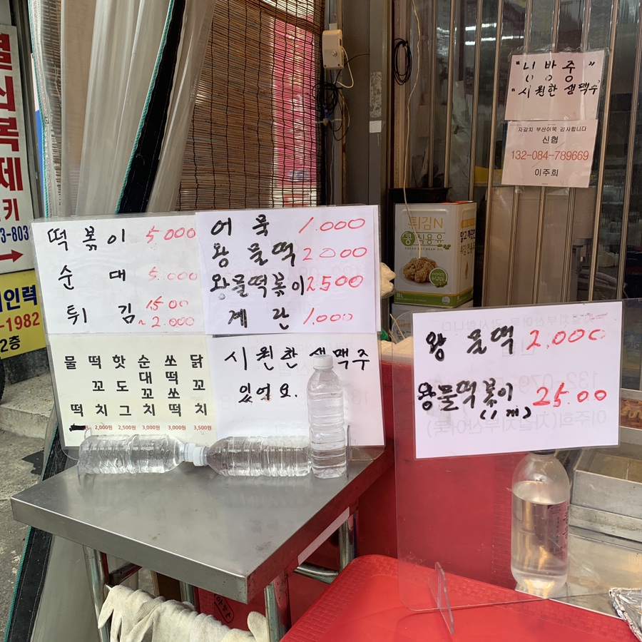 Street food menu showing Seokchon Station tteokbokki, fish cakes, and mul-tteok prices at Jagalchi Busan Eomuk