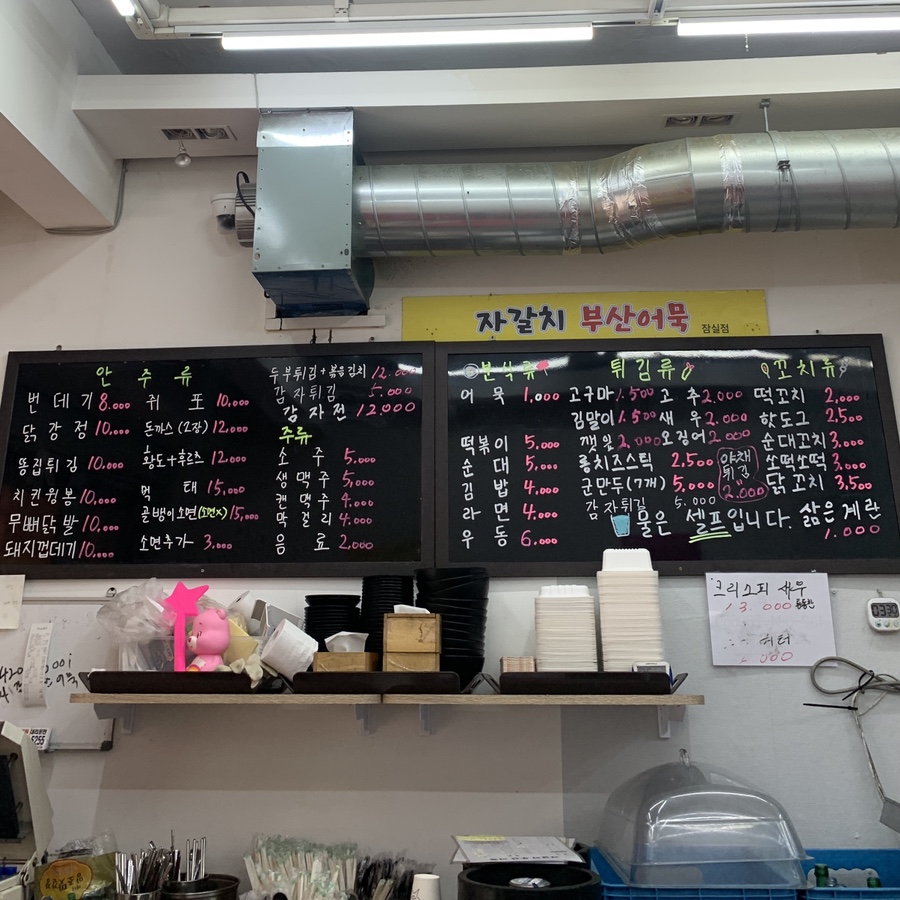 Indoor blackboard menu at Jagalchi Busan Eomuk serving Seokchon Station tteokbokki, eomuk, and Busan-style snacks