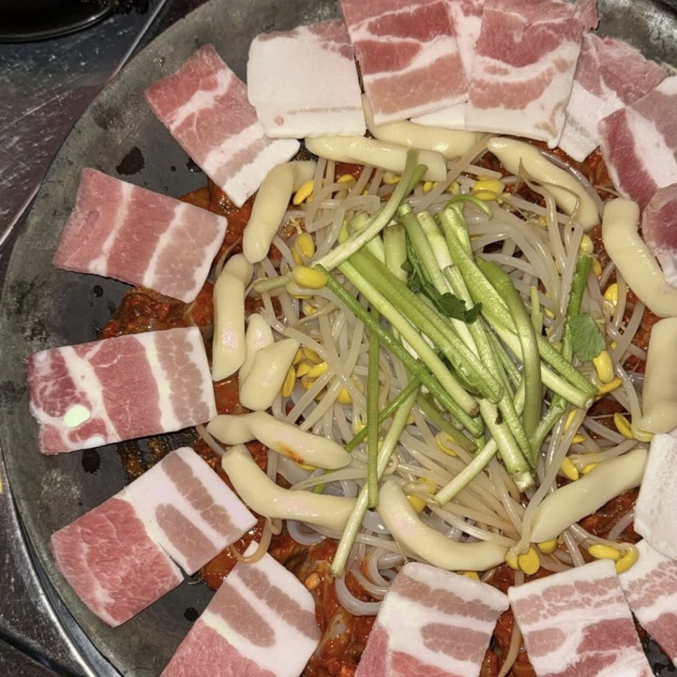 spicy Songridan-gil jjukkumi hotplate with pork belly, rice cakes, and bean sprouts
