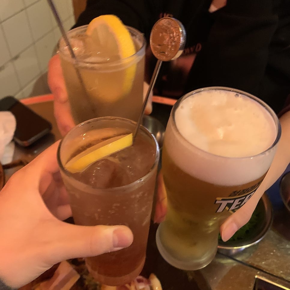 highball and draft beer glasses raised for cheers