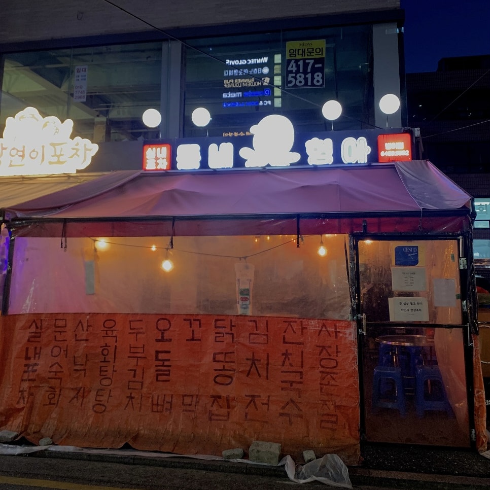 Korean pocha exterior with warm tent lighting near Seokchon Lake in Jamsil