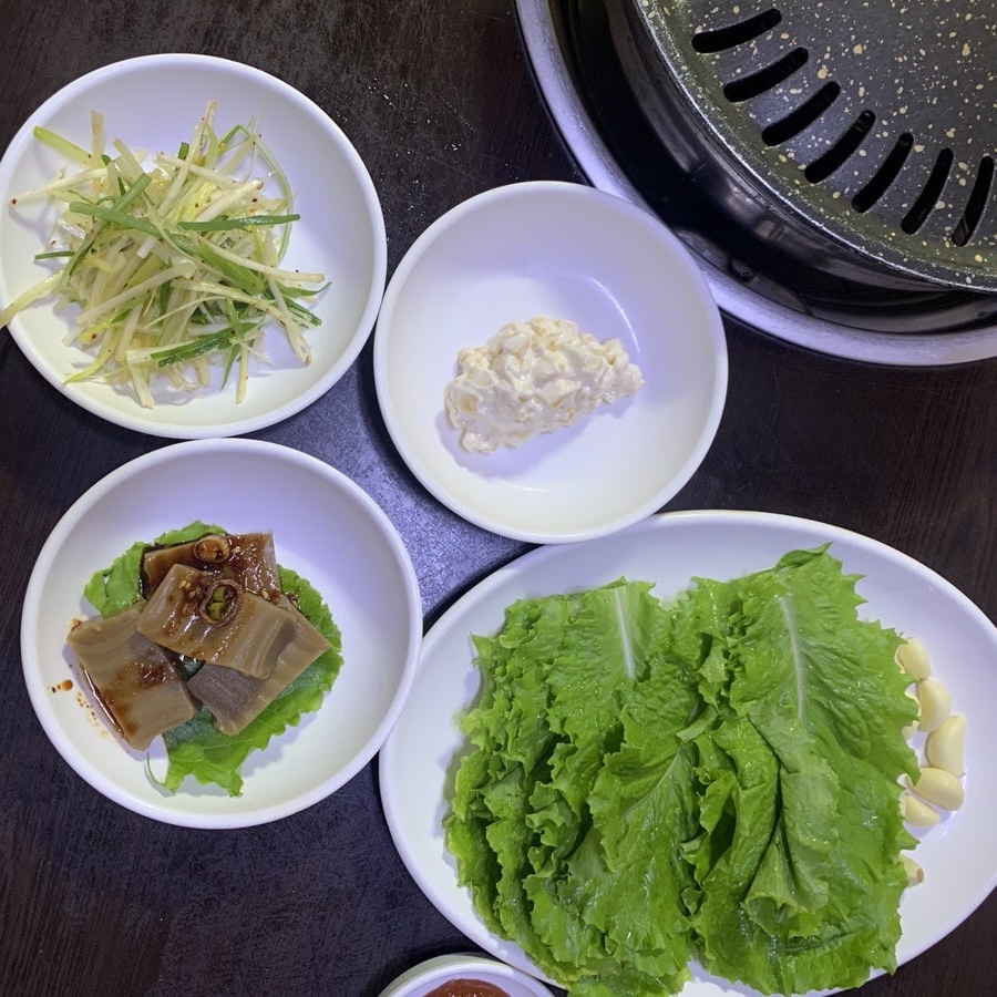 Korean side dishes at a Bukchon Korean Restaurant including kimchi and lettuce