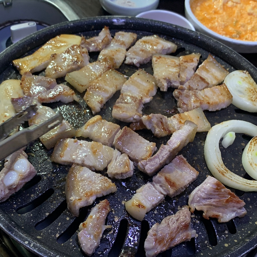 Cutting grilled pork belly into bite-sized pieces at Jaedong Sundubu