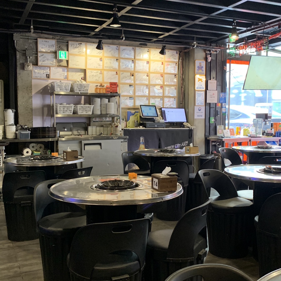 Interior of Jingu Gopchang with grill tables and autograph wall — Gangnam Gopchang