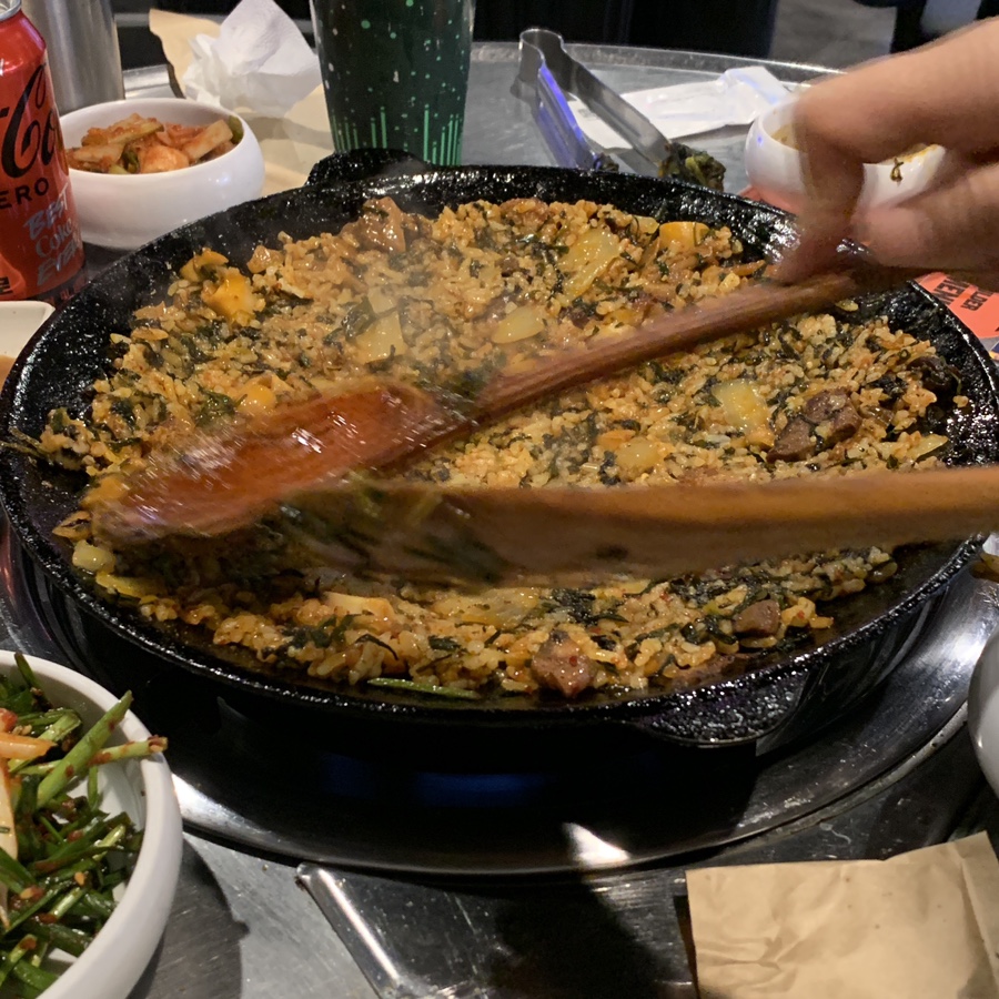Stir-fried kimchi rice being cooked in a hot pan at Jingu Gopchang — Gangnam Gopchang