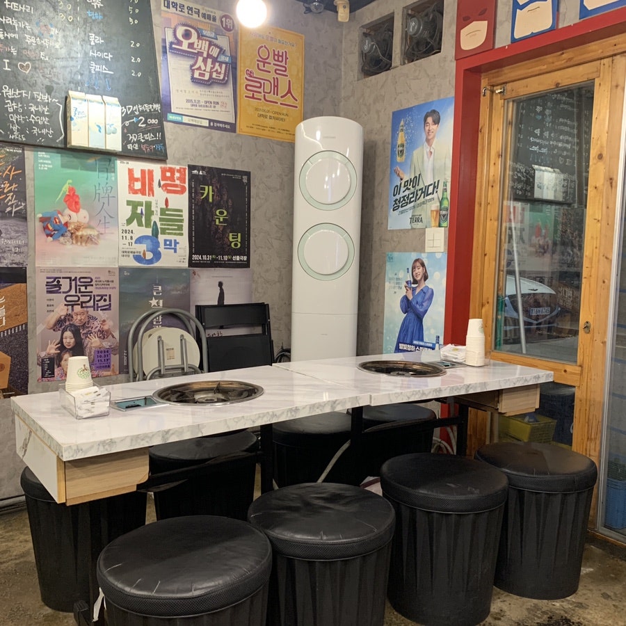 Indoor seating area at a Hyehwa gopchang restaurant with posters and casual tables