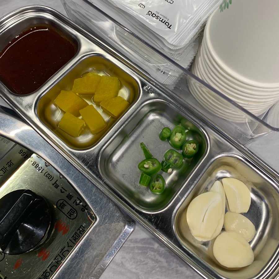 Side dish tray with pickles, green peppers, and garlic at Hong Gopchang Hyehwa