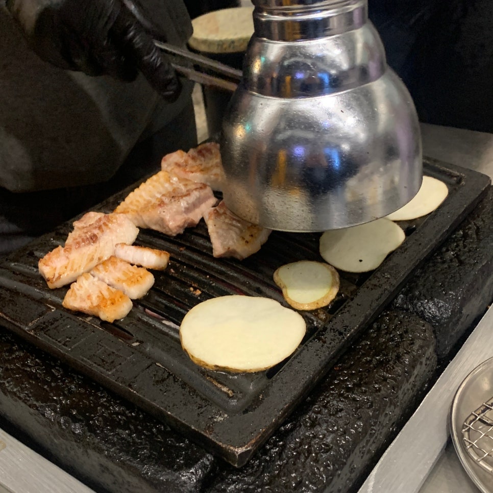 Staff grilling pork BBQ at Seokchon Station Bondi Jamsil