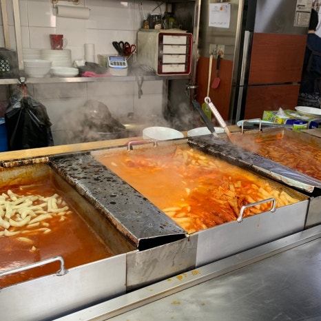 Tteokbokki and soondae combo served on cafeteria-style trays
