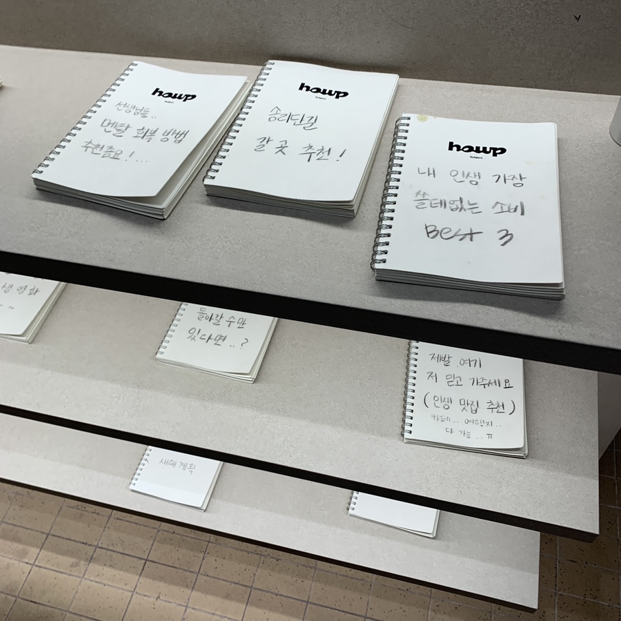 Community notebook shelf with handwritten stories at Howp Songridan-gil Cafe