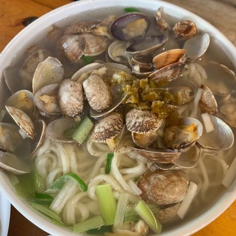 Large bowl of clam kalguksu with fresh clams and handmade noodles in Euljiro