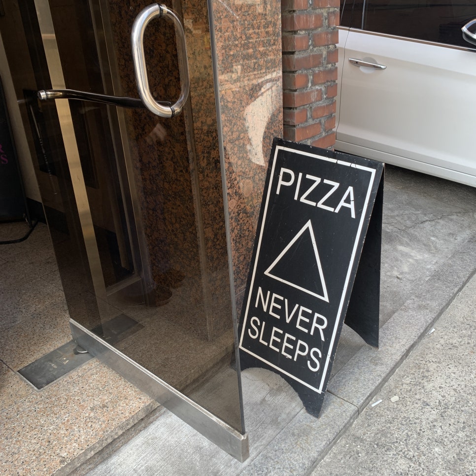 Pizza Never Sleeps Songridan-gil entrance sign near basement restaurant