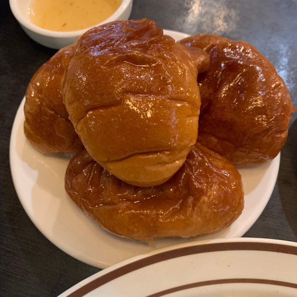 Warm butter rolls with glossy surface served at Tonkatsu House Jamsil, accompanied by strawberry jam