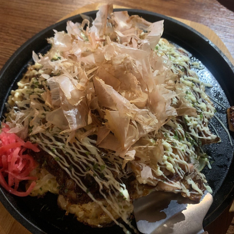 Japanese okonomiyaki topped with bonito flakes and sauce at an izakaya in Seoul