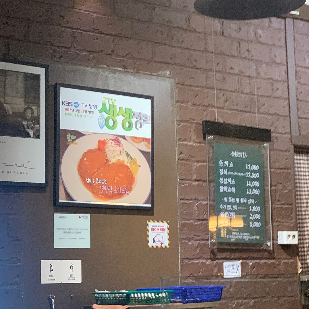 Menu board and TV feature display at Tonkatsu House Jamsil, known for classic Korean tonkatsu