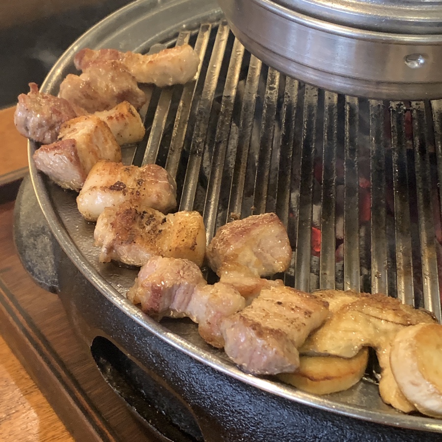 grilled samgyeopsal arranged on grill ready to eat korean bbq