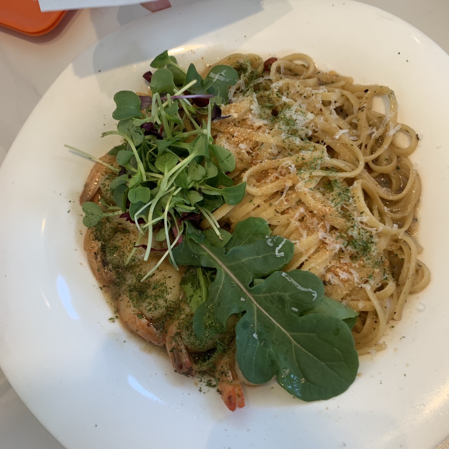 Shrimp aglio olio pasta with fresh greens and parmesan cheese