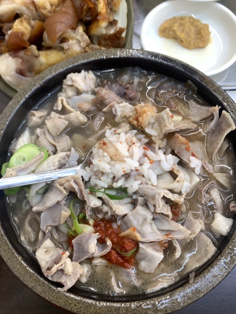 Korean pork blood sausage soup with chili paste and green onions in stone bowl