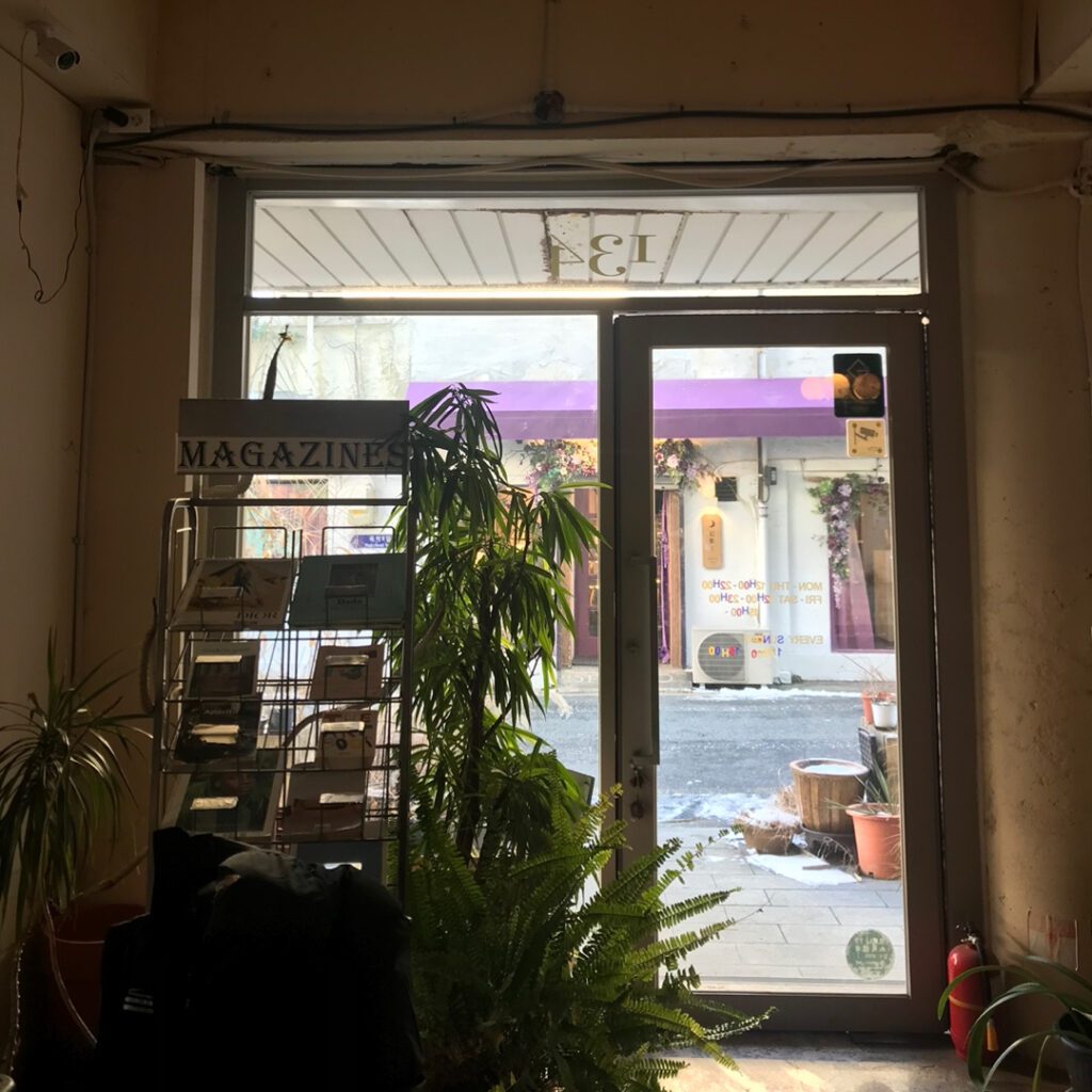 Entrance of Kofe Bush Cafe in Daejeon with plants and cozy interior