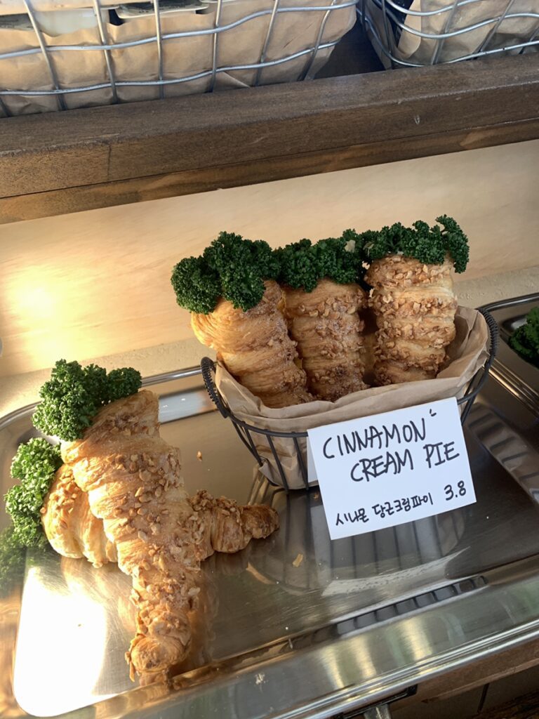 Cinnamon cream pie croissant pastries with nut topping arranged in warm bakery basket display