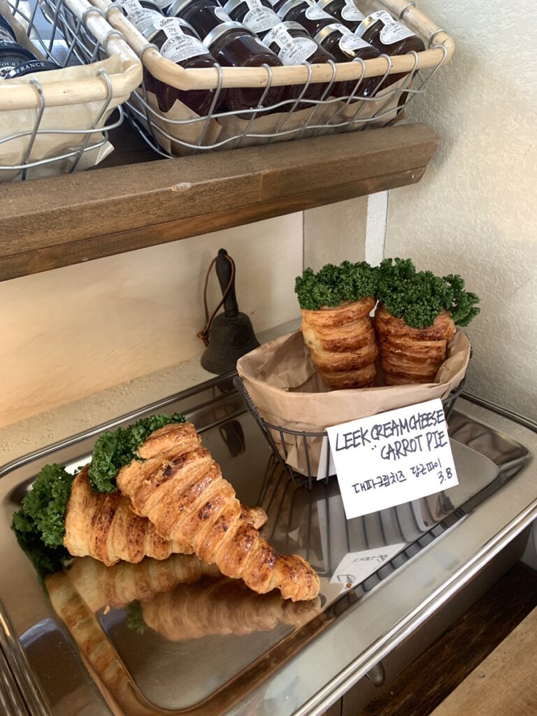 Croissant-style leek cream cheese carrot pie bakery display in rustic basket with parsley topping