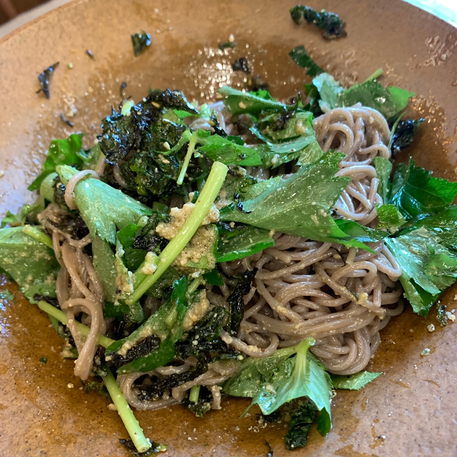 Buckwheat noodles mixed with greens and seaweed in Korean sesame oil style bowl