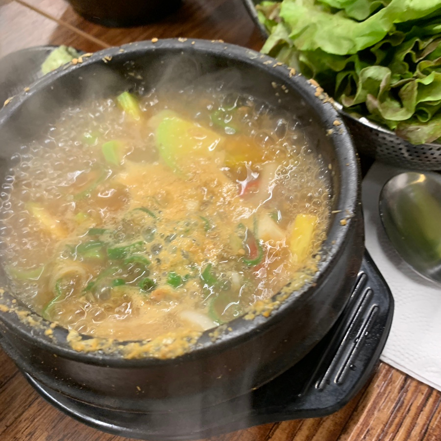 Traditional Korean doenjang stew served with fresh lettuce at a Korean BBQ restaurant