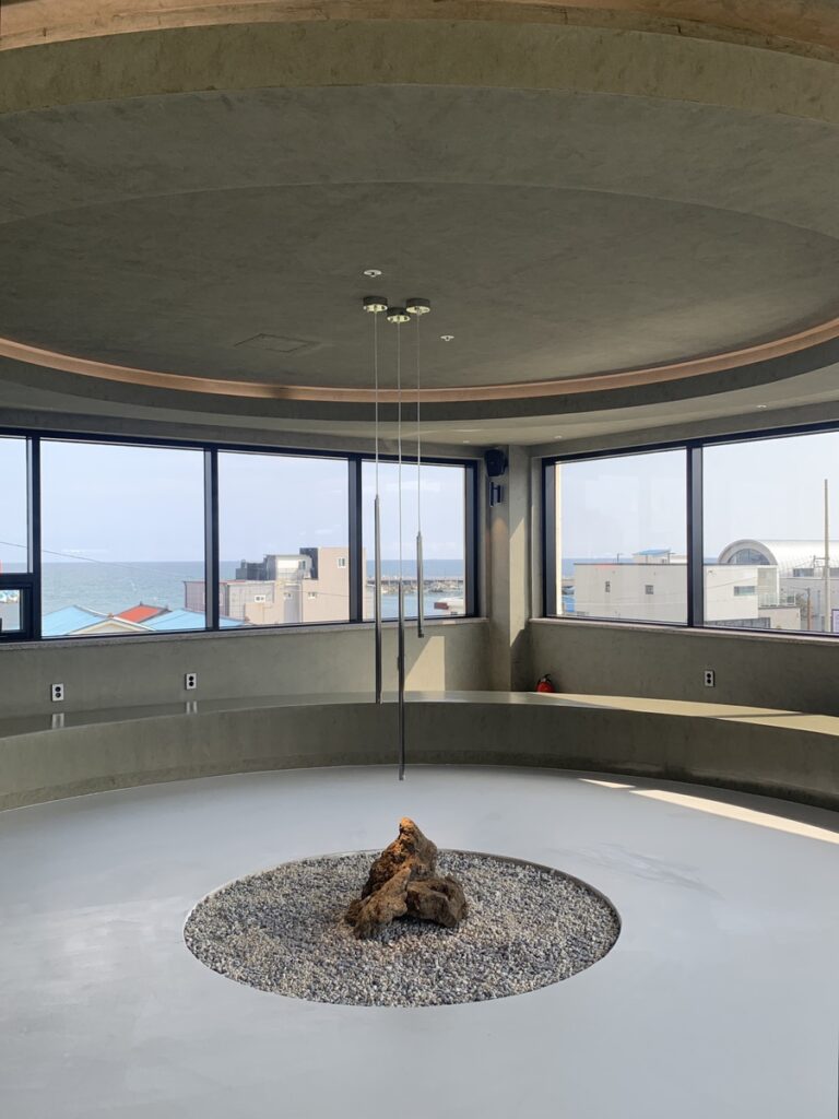Minimal concrete interior with ocean view at The Woosan Gijang Cafe
