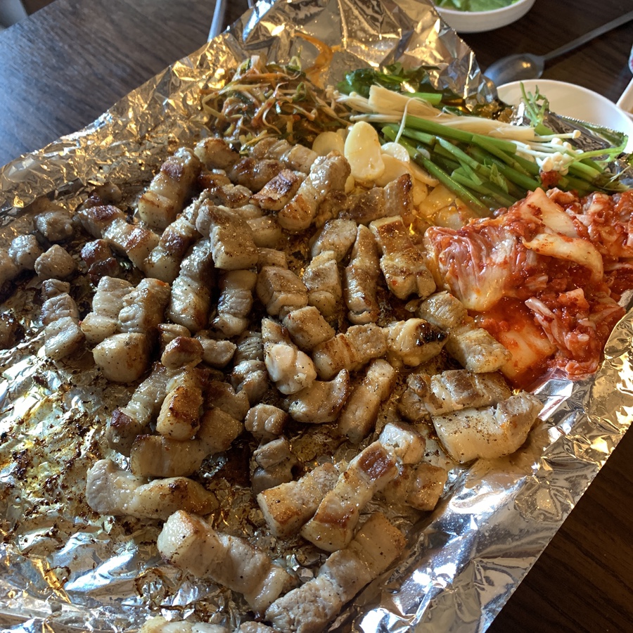 Ikseondong Samgyeopsal grilled with kimchi, minari, and green onions at Goundon
